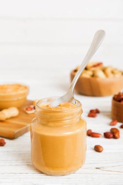 Arka planda bir kase fıstık ezmesi ve fıstık. Kopyalama alanı olan üst görünüm. Küçük kasede kremalı fıstıklı makarna.