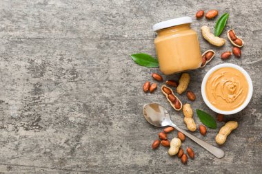 Arka planda bir kase fıstık ezmesi ve fıstık. Kopyalama alanı olan üst görünüm. Küçük kasede kremalı fıstıklı makarna.