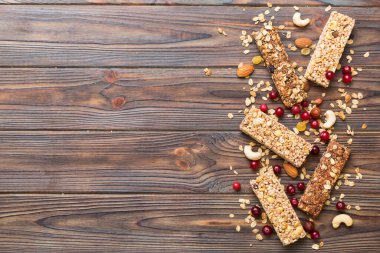 Arka planda çeşitli granola barlar var. Mısır gevreği gofretleri. Yulaf, fındık ve böğürtlenli kahvaltı barları, yakın çekim. Süper yiyecek konsepti.