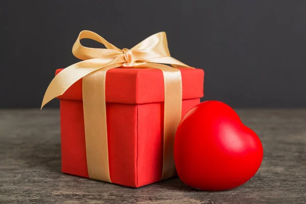 stock image gift box with red bow and red heart on colored background. Perspective view. Flat lay.