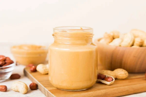 stock image Bowl of peanut butter and peanuts on table background. top view with copy space. Creamy peanut pasta in small bowl.