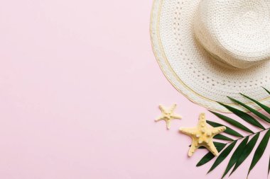 Summer holidays. Summer concept with straw hat and tropical leaf. Flat lay, top view, copy space.