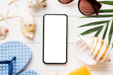 Renkli arka planda telefon ve plaj aksesuarları olan düz kompozisyon. Boş ekran ile akıllı telefon kopyalama alanı ile taklit.