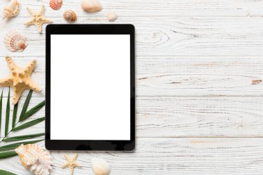 Renkli arka planda tablet ve plaj aksesuarlarıyla düz kompozisyon. Boş ekran ile tablet bilgisayarı kopyalama alanı ile maket.