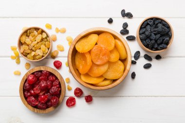 Masa arkasında farklı kurumuş meyveler olan bir kase, üst manzara. Kopyalama alanı olan sağlıklı yaşam biçimi.