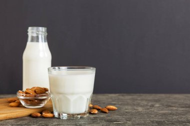 Cam şişedeki badem sütü ve renkli masada badem fıstığı. Üst görünüm vith kopyalama alanı.