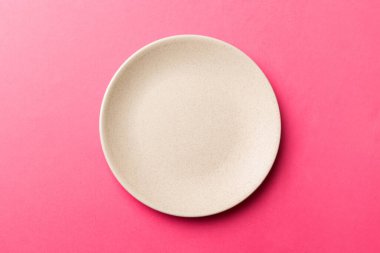 Top view of isolated of colored background empty round beige plate for food. Empty dish with space for your design. clipart