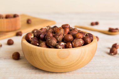 Wooden bowl full of hazelnuts on table background. Healthy eating concept. Super foods.