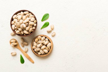 Fresh healthy Pistachios in bowl on colored table background. Top view. Healthy eating concept. Super foods.
