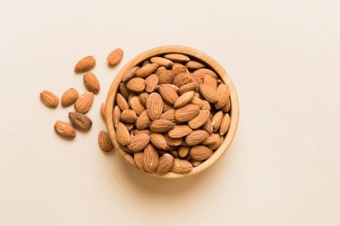 Fresh healthy Almond in bowl on colored table background. Top view.