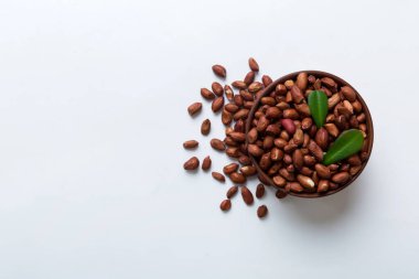 Fresh healthy peanuts in bowl on colored table background. Top view Healthy eating bertholletia concept. Super foods.