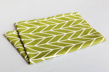 top view with green kitchen napkin isolated on table background. Folded cloth for mockup with copy space, Flat lay. Minimal style.