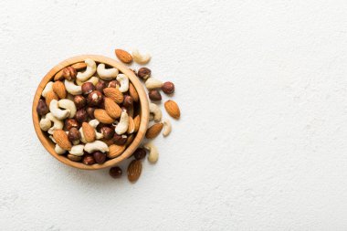 Renkli masadaki ahşap kasede fındık çeşitleri. Ceviz, fındık, ceviz, badem. Fındık Üst görünümü ile kopyalama alanını karıştır.