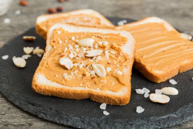 Fıstık ezmeli sandviç ya da arka planda kızarmış ekmek. Kahvaltı. Vejetaryen yemeği. Amerikan mutfağının üst görünümü kopyalama alanı.