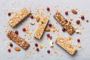 Arka planda çeşitli granola barlar var. Mısır gevreği gofretleri. Yulaf, fındık ve böğürtlenli kahvaltı barları, yakın çekim. Süper yiyecek konsepti.