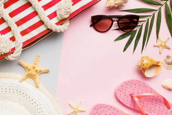 stock image Beach accessories straw hat and seashell on colored table. Summer concept background.