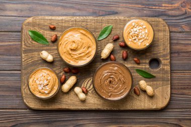 Masa arkasında fıstık ezmesi tabağı olan cam kavanoz, metin için üst görünüm alanı ve kapatma.