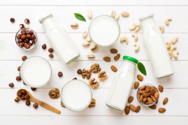 Masa arkasında çeşitli vejetaryen süt bademi, kaju fıstığı seti ya da koleksiyonu. Vejetaryen bitkisi sütü ve malzemeleri, üst görünüm.