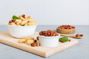 Fresh healthy peanuts in bowl on colored table background. Top view Healthy eating bertholletia concept. Super foods.