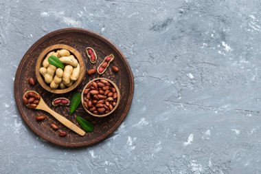 Fresh healthy peanuts in bowl on colored table background. Top view Healthy eating bertholletia concept. Super foods.