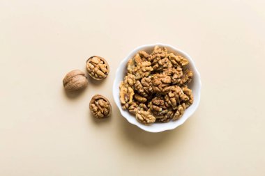 Fresh healthy walnuts in bowl on colored table background. Top view Healthy eating bertholletia concept. Super foods.