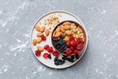 Sağlıklı bir kahvaltı hazırlıyorum. Bir kasede çeşitli kurutulmuş meyve ve fındıklı granola. Sağlıklı tatlı kavramı. Düz konum, kopyalama alanı olan üst görünüm.