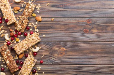 Arka planda çeşitli granola barlar var. Mısır gevreği gofretleri. Yulaf, fındık ve böğürtlenli kahvaltı barları, yakın çekim. Süper yiyecek konsepti.