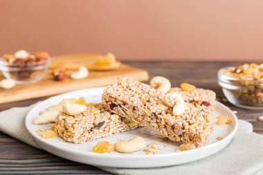 Arka planda çeşitli granola barlar var. Mısır gevreği gofretleri. Yulaf, fındık ve böğürtlenli kahvaltı barları, yakın çekim. Süper yiyecek konsepti.