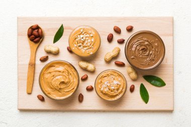 Masa arkasında fıstık ezmesi tabağı olan cam kavanoz, metin için üst görünüm alanı ve kapatma.