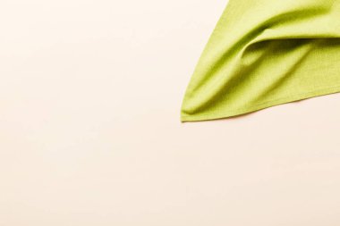 top view with green kitchen napkin isolated on table background. Folded cloth for mockup with copy space, Flat lay. Minimal style.