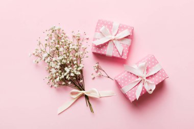 Hediye kutusu ya da hediye kutusu ve çiçek çıngıraklı yılanı ışık masasının üstünde. Tebrik kartı. Kopya alanı ile düz uzanma biçimi.