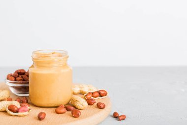 Arka planda bir kase fıstık ezmesi ve fıstık. Kopyalama alanı olan üst görünüm. Küçük kasede kremalı fıstıklı makarna.