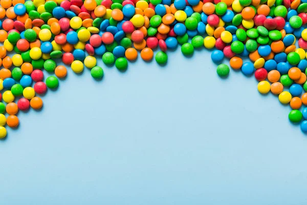 Mixed collection of colorful candy, on colored background. Flat lay, top view. frame of colorful chocolate coated candy.