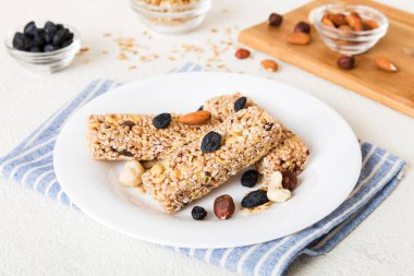 Arka planda çeşitli granola barlar var. Mısır gevreği gofretleri. Yulaf, fındık ve böğürtlenli kahvaltı barları, yakın çekim. Süper yiyecek konsepti.