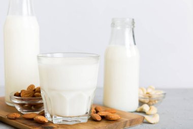 Masa arkasında çeşitli vejetaryen süt bademi, kaju fıstığı seti ya da koleksiyonu. Vejetaryen bitkisi sütü ve malzemeleri, üst görünüm.