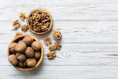 Fresh healthy walnuts in bowl on colored table background. Top view Healthy eating bertholletia concept. Super foods.