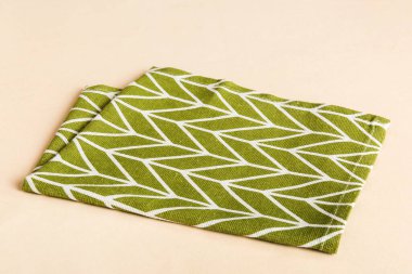 top view with green kitchen napkin isolated on table background. Folded cloth for mockup with copy space, Flat lay. Minimal style.