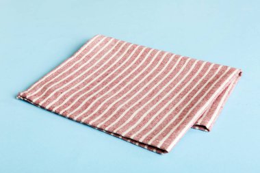 top view with red empty kitchen napkin isolated on table background. Folded cloth for mockup with copy space, Flat lay. Minimal style.
