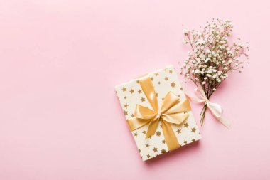 Hediye kutusu ya da hediye kutusu ve çiçek çıngıraklı yılanı ışık masasının üstünde. Tebrik kartı. Kopya alanı ile düz uzanma biçimi.