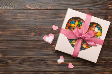 Valentine day composition: sweet candy, with gift boxes with bow and red felt hearts, photo template, background. Top View with copy space.