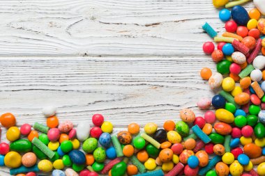 Renkli arka planda karışık renkli şeker koleksiyonu. Düz yerde, üst tarafta. Renkli çikolata kaplı şeker çerçevesi.