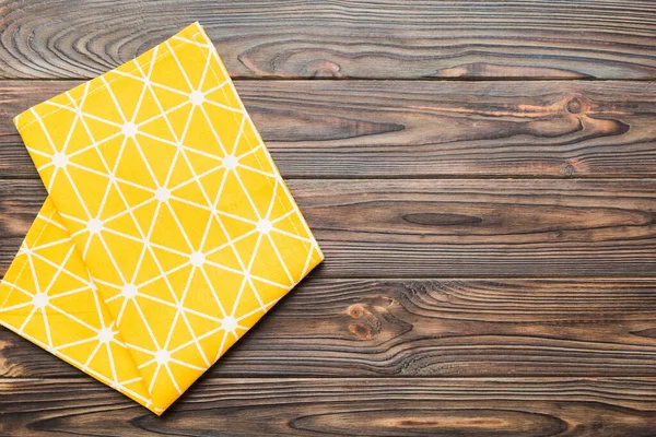 stock image top view with yellow empty kitchen napkin isolated on table background. Folded cloth for mockup with copy space, Flat lay. Minimal style.