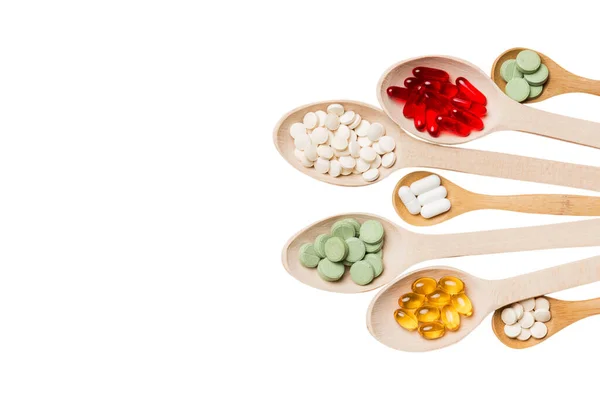 Renkli arka planda tahta kaşıkta vitamin ve mineral haplarının üst görünümü. Muhtelif ilaç haplarının en üst görüntüsü. Beslenme takviyesi sağlık ürünleri.