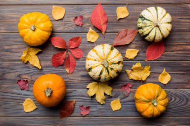 Sonbahar kompozisyonu. Masadaki kurumuş yapraklar ve diğer tasarım aksesuarlarından oluşan desen. Düz yatış, üst görünüm.