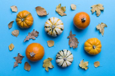 Sonbahar kompozisyonu. Masadaki kurumuş yapraklar ve diğer tasarım aksesuarlarından oluşan desen. Düz yatış, üst görünüm.