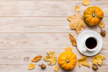 Renkli sonbahar kahve fincanı ve renkli yapraklarla bezenmiş düz bir kompozisyon. en üstteki görünüm.