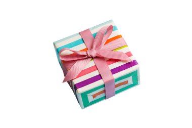 Noel 'i ya da diğer tatil hediyelerini renkli arka planda kurdeleyle renkli kağıda sardım. Şimdiki kutu, renkli tabloda hediye süslemesi, kopya alanı ile üst görünüm.