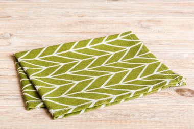 top view with green kitchen napkin isolated on table background. Folded cloth for mockup with copy space, Flat lay. Minimal style.