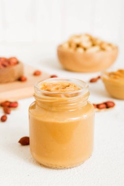 Arka planda bir kase fıstık ezmesi ve fıstık. Kopyalama alanı olan üst görünüm. Küçük kasede kremalı fıstıklı makarna.