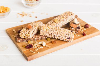 Arka planda çeşitli granola barlar var. Mısır gevreği gofretleri. Yulaf, fındık ve böğürtlenli kahvaltı barları, yakın çekim. Süper yiyecek konsepti.